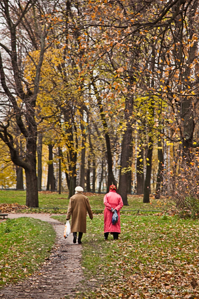 Two babushkas walking in Tavricheskiy Sad in autumn; Saint Petersburg, Russia.